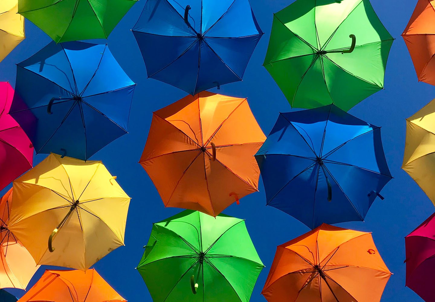  Colorful umbrellas against a blue sky represent the search query 'Umbrella insurance coverage benefits'.